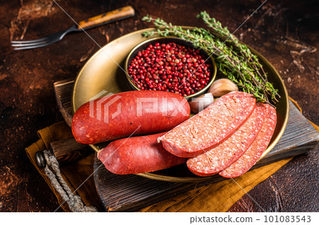 Sliced halal Sucuk beef meat sausage. Dark background. Top view Sliced halal Sucuk beef meat sausage. Dark background. Top view 101083543