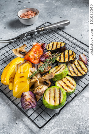 Seasonal summer Grilled vegetables on a grill, bell pepper, zucchini, eggplant, onion and tomato. Gray background. Top view Seasonal summer Grilled vegetables on a grill, bell pepper, zucchini, eggplant, onion and tomato. Gray background. Top view 101083549
