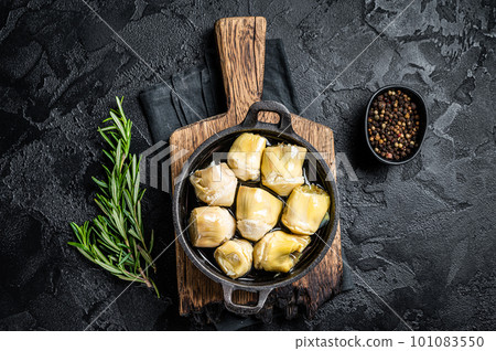 Artichoke hearts pickled in olive oil with herbs and spices Black background. Top view 101083550