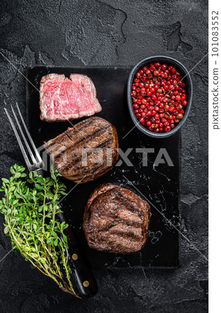 Grilled Fillet Mignon Steaks, dry aged beef tenderloin meat. Black background. Top view 101083552