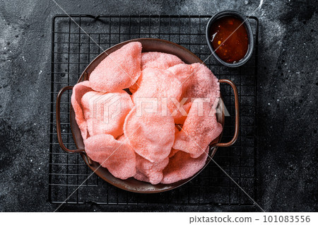 Vietnamese prawn shrimp crackers, chips, kerupuk. Asian fastfood. Black background. Top view Vietnamese prawn shrimp crackers, chips, kerupuk. Asian fastfood. Black background. Top view 101083556