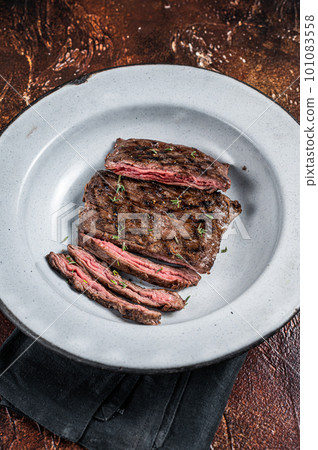 Homemade Cooked Skirt steak on a grill. Dark background. Top view 101083558