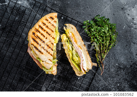 Grilled panini with Prosciutto ham, salad and cheese. Black background. top view 101083562