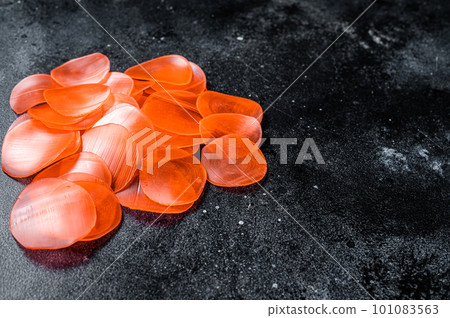 Raw kerupuk or prawn shrimp crackers, chips. Black background. Top view. Copy space Raw kerupuk or prawn shrimp crackers, chips. Black background. Top view. Copy space 101083563