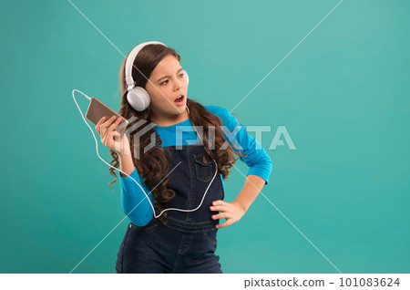 small girl use mp3 player. study in modern life. schoolgirl use digital device. casual fashion for kids. kid long hair listen music in headset. small child make play list on smartphone. copy space 101083624