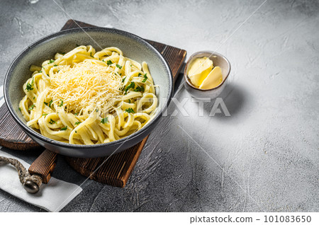 Spaetzle German egg noodles with cheese served with parsley. White background. Top view. Copy space Spaetzle German egg noodles with cheese served with parsley. White background. Top view. Copy space 101083650