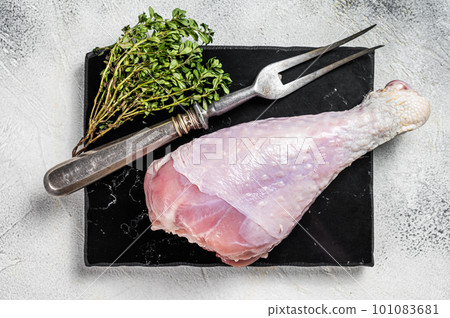 Raw turkey leg thigh with thyme and spices. White background. Top view 101083681