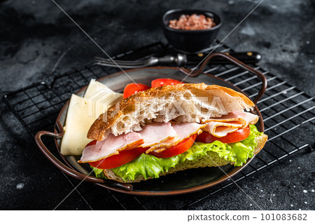 Deli meat sandwich with turkey ham, cheese, tomato and Lettuce. Black background. Top view 101083682