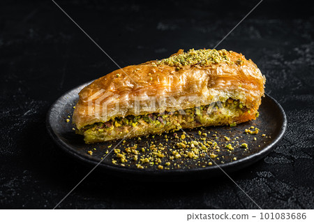 Turkish Havuc Dilim Baklava with pistachio, Carrot Slice Baklava. Black background. Top view Turkish Havuc Dilim Baklava with pistachio, Carrot Slice Baklava. Black background. Top view 101083686