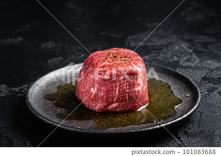 Fillet Mignon prime beef steak, raw dry aged marble meat with herbs and spices ready for cooking. Black background. Top view 101083688