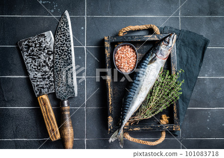 Raw mackerel fish with herbs and spices in wooden tray ready for cooking. Black background. Top view 101083718