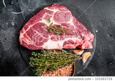 Pork loin steak, raw neck meat with thyme and salt. Black background. Top view Pork loin steak, raw neck meat with thyme and salt. Black background. Top view 101083728