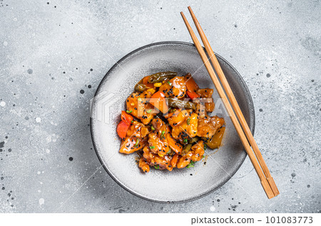Chinese Sweet and Sour Pork guo bao rou in a bowl. Gray background. Top view Chinese Sweet and Sour Pork guo bao rou in a bowl. Gray background. Top view 101083773