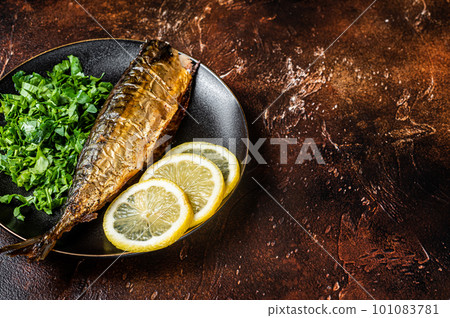 Grilled Mackerel Scomber fish on a plate with greens and lemon. Dark background. Top view. Copy space 101083781