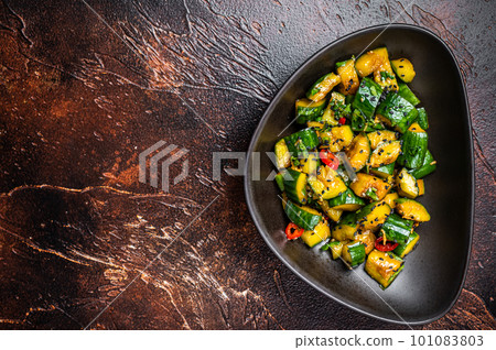 Chinese smashed cucumbers with herbs and sesame oil. Dark background. Top view. Copy space Chinese smashed cucumbers with herbs and sesame oil. Dark background. Top view. Copy space 101083803