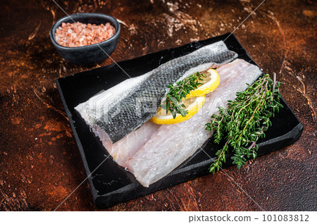 Sea Bass fillets, Raw Seabass fish with thyme, pink salt and lemon on marble board. Dark background. Top view Sea Bass fillets, Raw Seabass fish with thyme, pink salt and lemon on marble board. Dark background. Top view 101083812