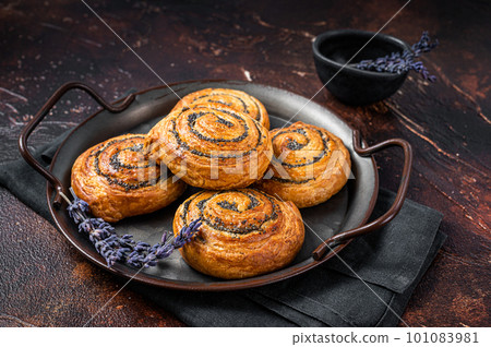 Sweet twisted Bun with poppy seeds and lavender. Dark background. Top view 101083981