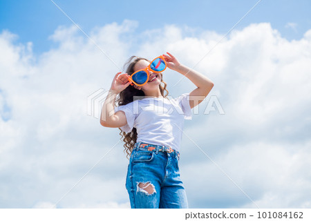 kid fashion and beauty. sense of freedom. portrait of pretty child girl in party glasses. concept of summer. happy childhood. cheerful teen girl has long curly hair. kid smiling outdoor kid fashion and beauty. sense of freedom. portrait of pretty child girl in party glasses. concept of summer. happy childhood. cheerful teen girl has long curly hair. kid smiling outdoor 101084162