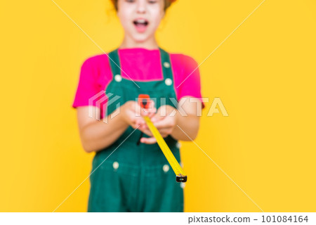 happy kid engineer with tape measure tool in hard hat, measuring, selective focus happy kid engineer with tape measure tool in hard hat, measuring, selective focus 101084164