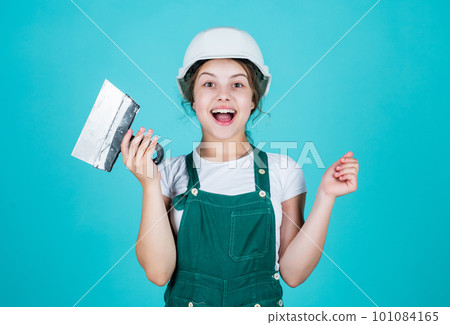 Building is her life. girl working with spatula. small builder using putty knife. kid with helmet holding spatula. kid bricklayer masonry worker with helmet and trowel putty knife. house renovation Building is her life. girl working with spatula. small builder using putty knife. kid with helmet holding spatula. kid bricklayer masonry worker with helmet and trowel putty knife. house renovation 101084165