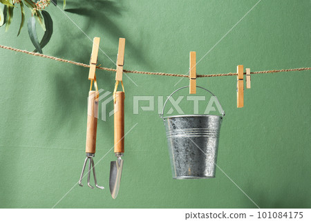 Gardening tools hanging on the rope, natural green background Gardening tools hanging on the rope, natural green background 101084175