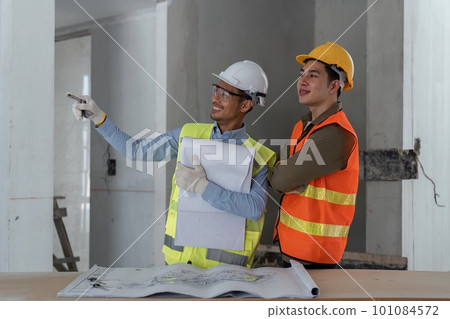 architect watching some details in blueprint a construction site 101084572