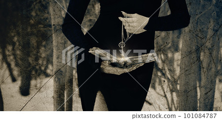 Beautiful faceless witch in black tight dress with an open old book and a key in hands makes ritual in a black forest, selective focus. Beautiful faceless witch in black tight dress with an open old book and a key in hands makes ritual in a black forest, selective focus. 101084787