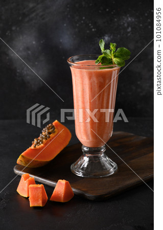 Papaya lassi in glass on black background. 101084956