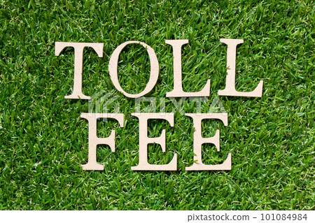Wood alphabet letter in word toll fee on artificial green grass background Wood alphabet letter in word toll fee on artificial green grass background 101084984