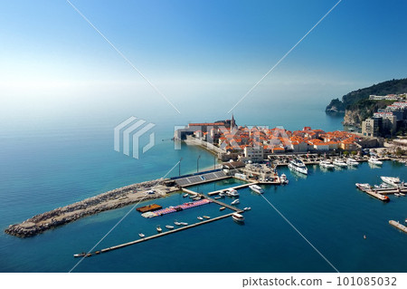 Aerial drone view of the ancient city of Budva on sunny day. Old medieval city with red roofs in Montenegro on the sunset. Aerial drone view of the ancient city of Budva on sunny day. Old medieval city with red roofs in Montenegro on the sunset. 101085032