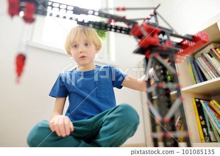 Preschooler boy playing with big construction building crane toy at home. Kids leisure activity. Entertainment for children indoors. Offline games. 101085135