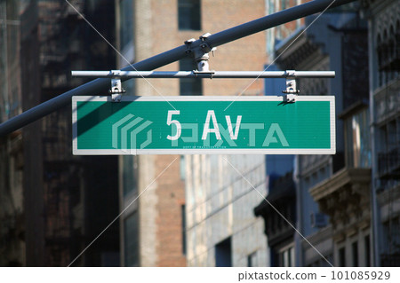 Green big 5 Av sign hanging on a arch pole in the streets of midtown Manhattan 101085929