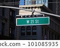 Green big West 21st Street sign hanging on a arch pole in the streets of midtown Manhattan 101085935
