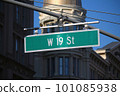 Green big West 19th Street sign hanging on a arch pole in the streets of midtown Manhattan 101085938