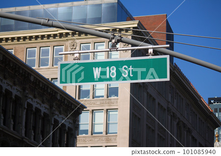 Green big West 18th Street sign hanging on a arch pole in the streets of midtown Manhattan Green big West 18th Street sign hanging on a arch pole in the streets of midtown Manhattan 101085940