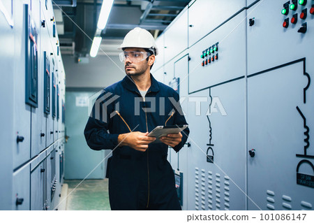 Electrician worker using tablet controlling machine at factory 101086147