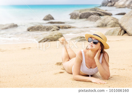 Woman lying on the sea beach 101086160