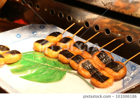 在夜間節日的夜攤上出售的醬油味磯部燒和磯部麻糬。 在夜間節日的夜攤上出售的醬油味磯部燒和磯部麻糬。 101086186