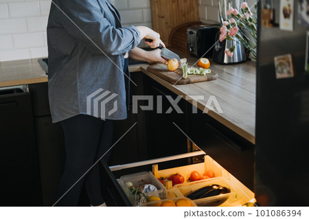 Food cravings during pregnancy. Why Pregnancy Can Make Have Weird Cravings. Craving fruits and vegetables during pregnancy. Pregnant woman cutting fruits in the kitchen Food cravings during pregnancy. Why Pregnancy Can Make Have Weird Cravings. Craving fruits and vegetables during pregnancy. Pregnant woman cutting fruits in the kitchen 101086394