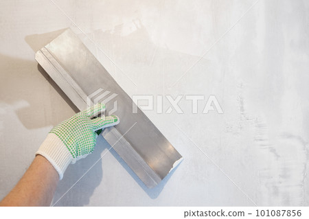 Hand holding a spatula. Tools, plaster wall 101087856