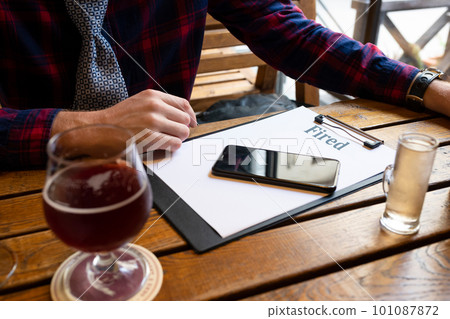 Alcoholism concept. Drunk unemployed man at the bar at the table, drinking beer alone.  101087872