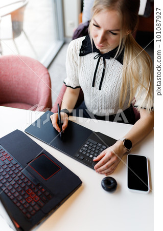 The girl works and studies with a graphic tablet 101087927