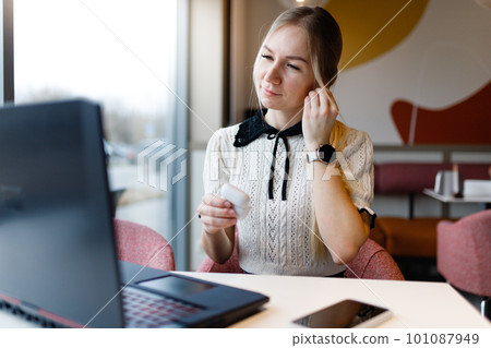 A girl works at a computer in a coffee shop. A girl works at a computer in a coffee shop. 101087949