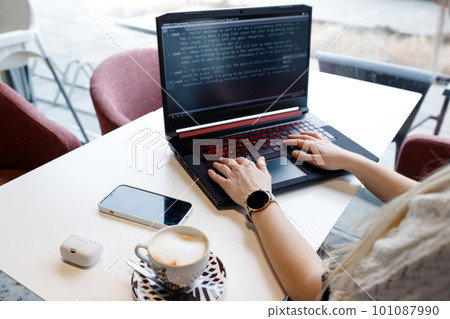 The girl programs on the computer over a cup of coffee 101087990