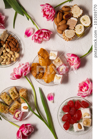 oriental sweets on a light background with pink tulips 101089770