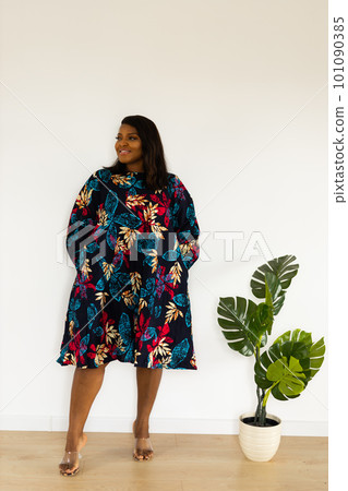 Young african american woman wearing dress posing over white wall at home - inclusion and diversity concept 101090385
