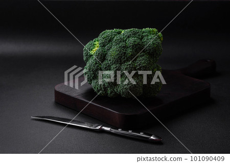 Raw fresh broccoli on a black home kitchen table 101090409