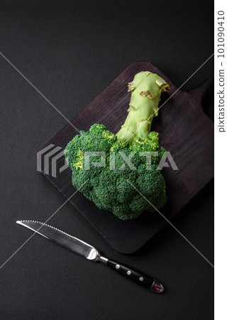 Raw fresh broccoli on a black home kitchen table 101090410