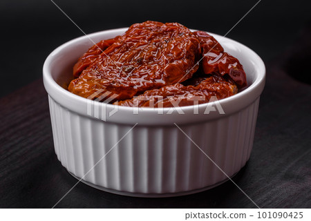 Delicious sun dried tomatoes in oil in a white ceramic bowl 101090425