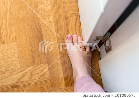 Woman hit furniture with the little toe. Incident at home. Injury of foot little finger 101090573